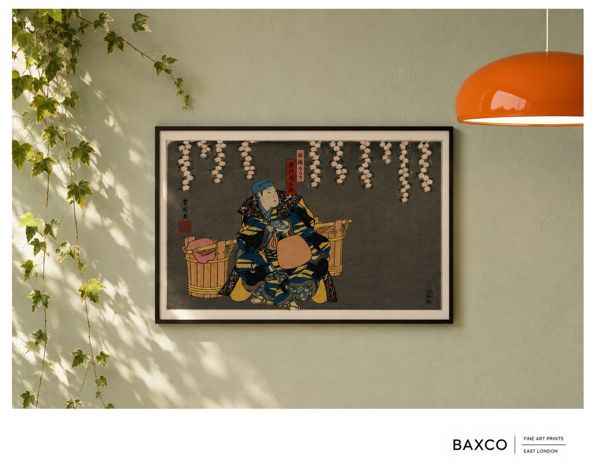 Hanami takes its name from the Japanese tradition of gathering to admire the fleeting beauty of flowers, most famously the spring cherry blossom.

This reproduction of an early 1860s colour woodcut by Utagawa Kunikazu depicts kabuki actors in a confrontation beneath cascading blossoms. Richly patterned robes of deep blue, black and gold stand dramatically against the charcoal ground, while the extraordinary sweep of blossom overhead gives the composition both theatricality and a surprising amount of stillne